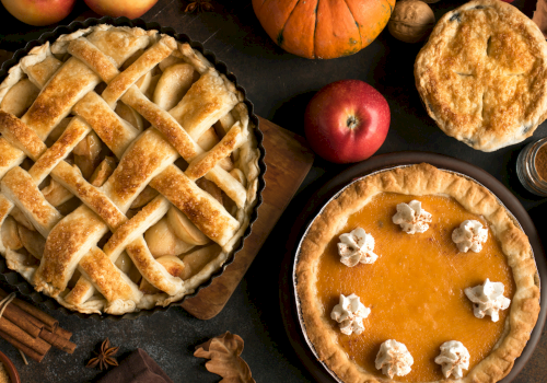 Delicious apple pies and pumpkins with autumn spices, perfect for a cozy fall dessert gathering.