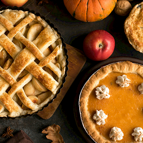 Delicious apple pies and pumpkins with autumn spices, perfect for a cozy fall dessert gathering.