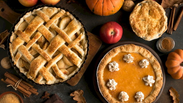 Delicious apple pies and pumpkins with autumn spices, perfect for a cozy fall dessert gathering.