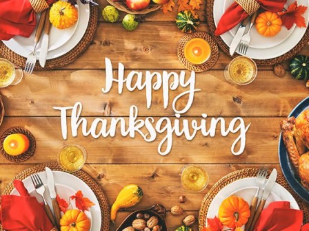 A festive Thanksgiving table with a roasted turkey, pumpkins, colorful leaves, candles, and set plates, creating a warm autumn atmosphere.